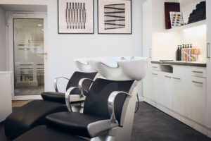 Detailaufnahme zweier Stühle mit Haarwaschbecken.