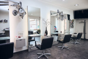 Innenraum des Friseursalons mit Stühlen und Spiegeln.